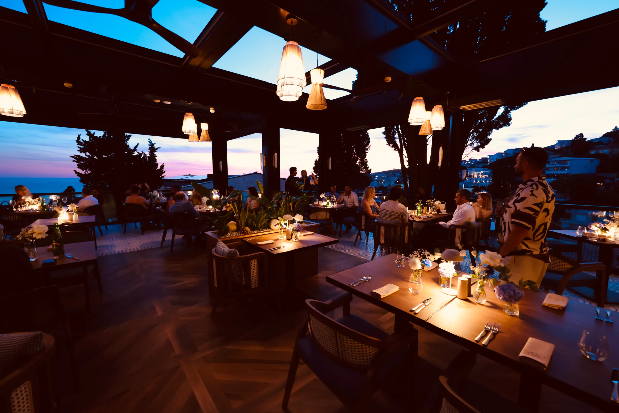 Fire-led plates and the long table at KALO, set against the Adriatic dusk.
